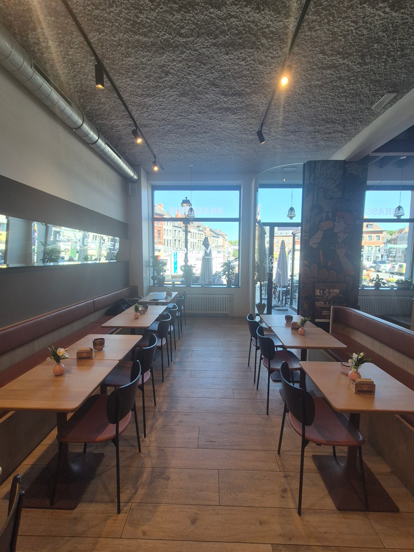 Grande salle avec banquettes cuir cognac et tables en chêne