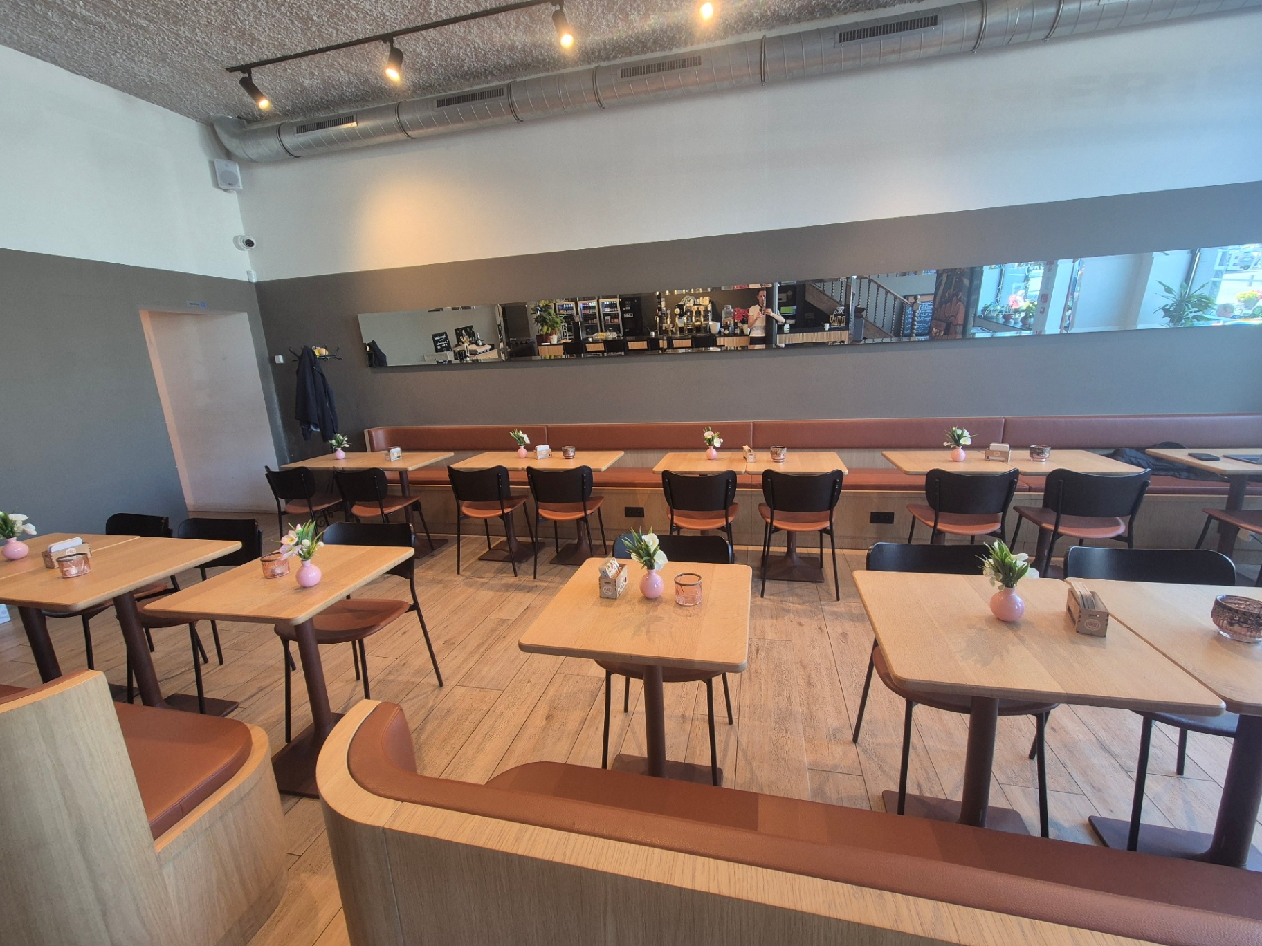 Salle du bas de la Brasserie Le Mercier à Ath — banquettes cuir cognac et tables en chêne
